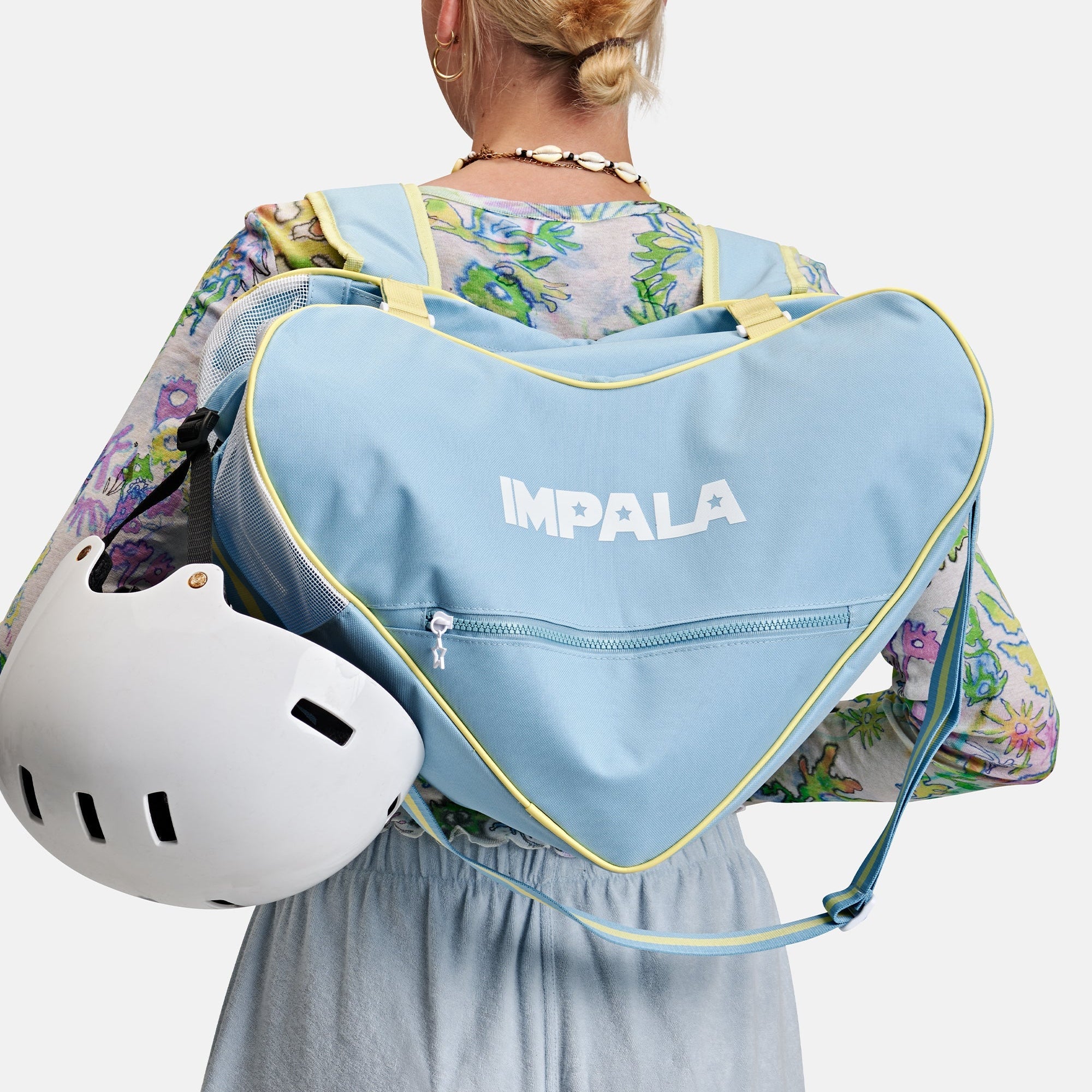Sky blue heart duffel skate bag with yellow piping, worn on shoulder, front logo.