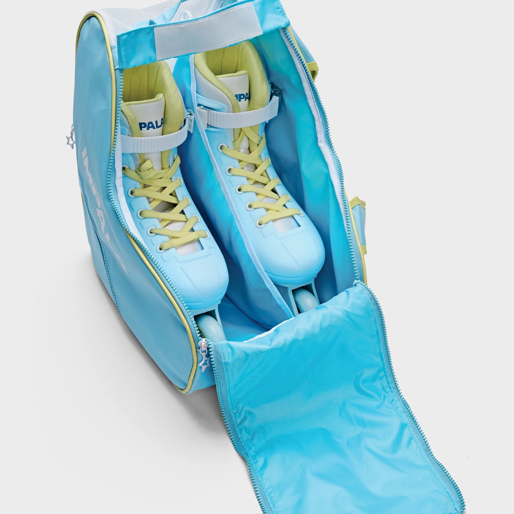 Open sky blue heart-shaped skate bag with yellow zipper trim and sneakers inside.