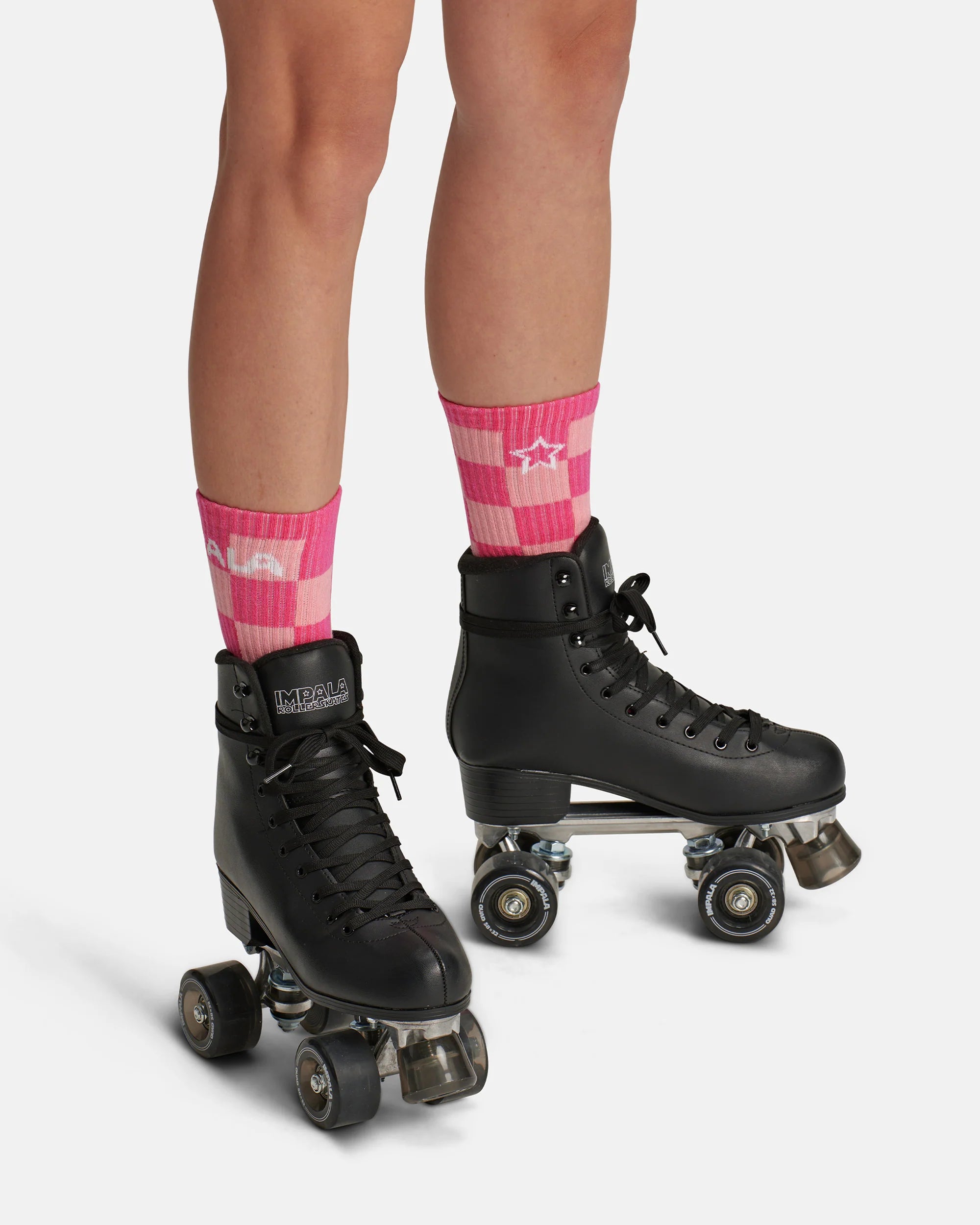 Pink check crew skate socks worn with black roller skates