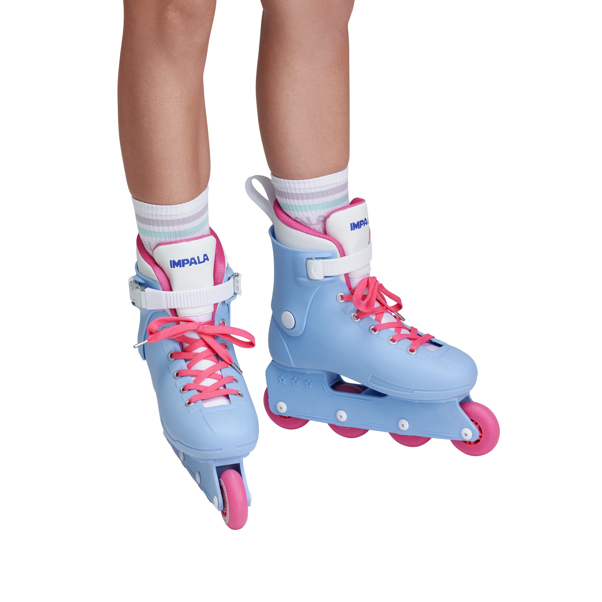 Pair of light blue inline skates on feet with pink laces and white straps