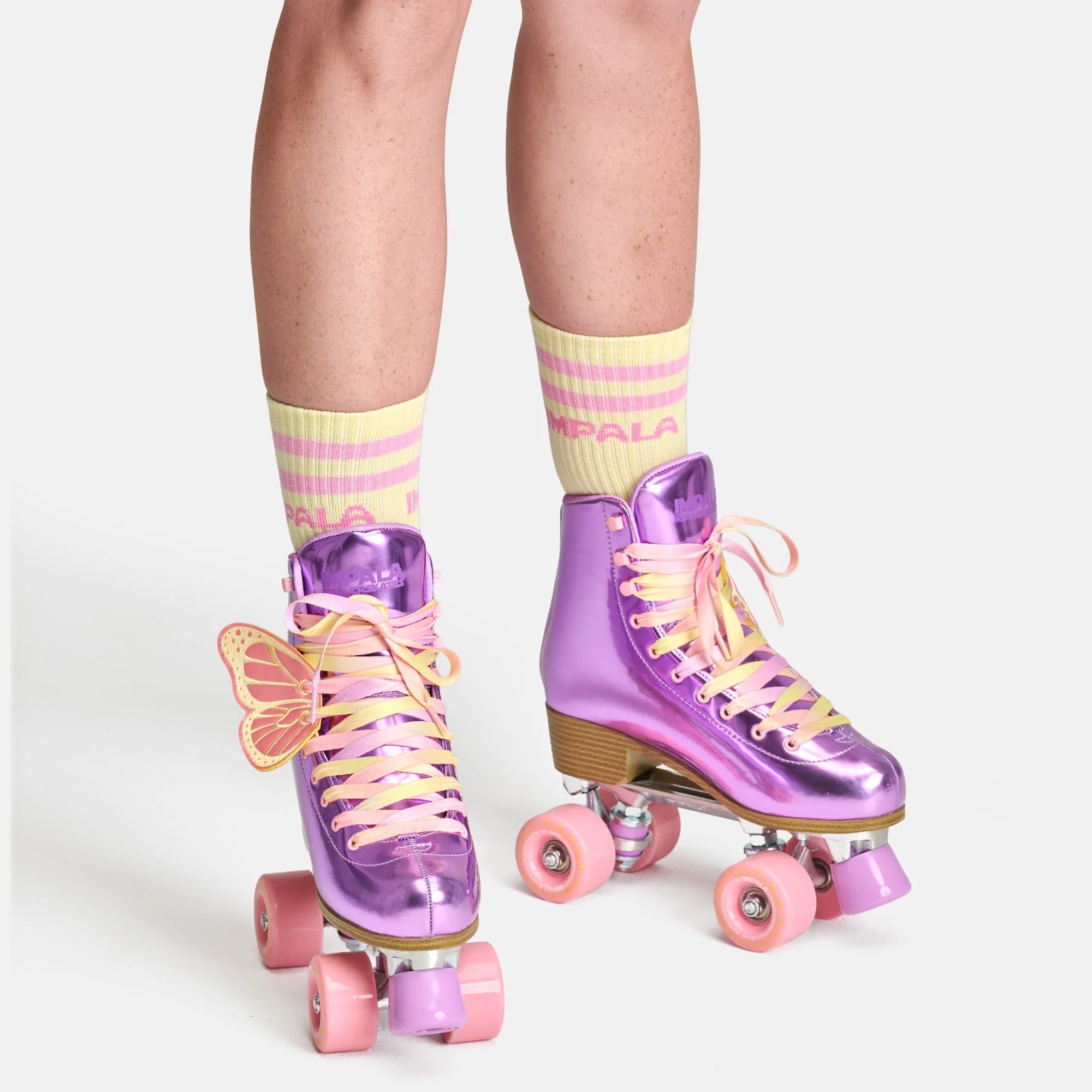 Lavender quad roller skates with pink wheels and yellow laces, shown standing