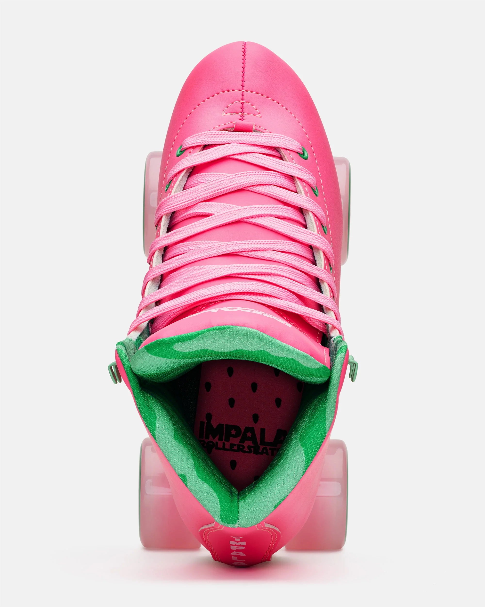 Front view pink quad skates with green interior, pink laces, and translucent wheels
