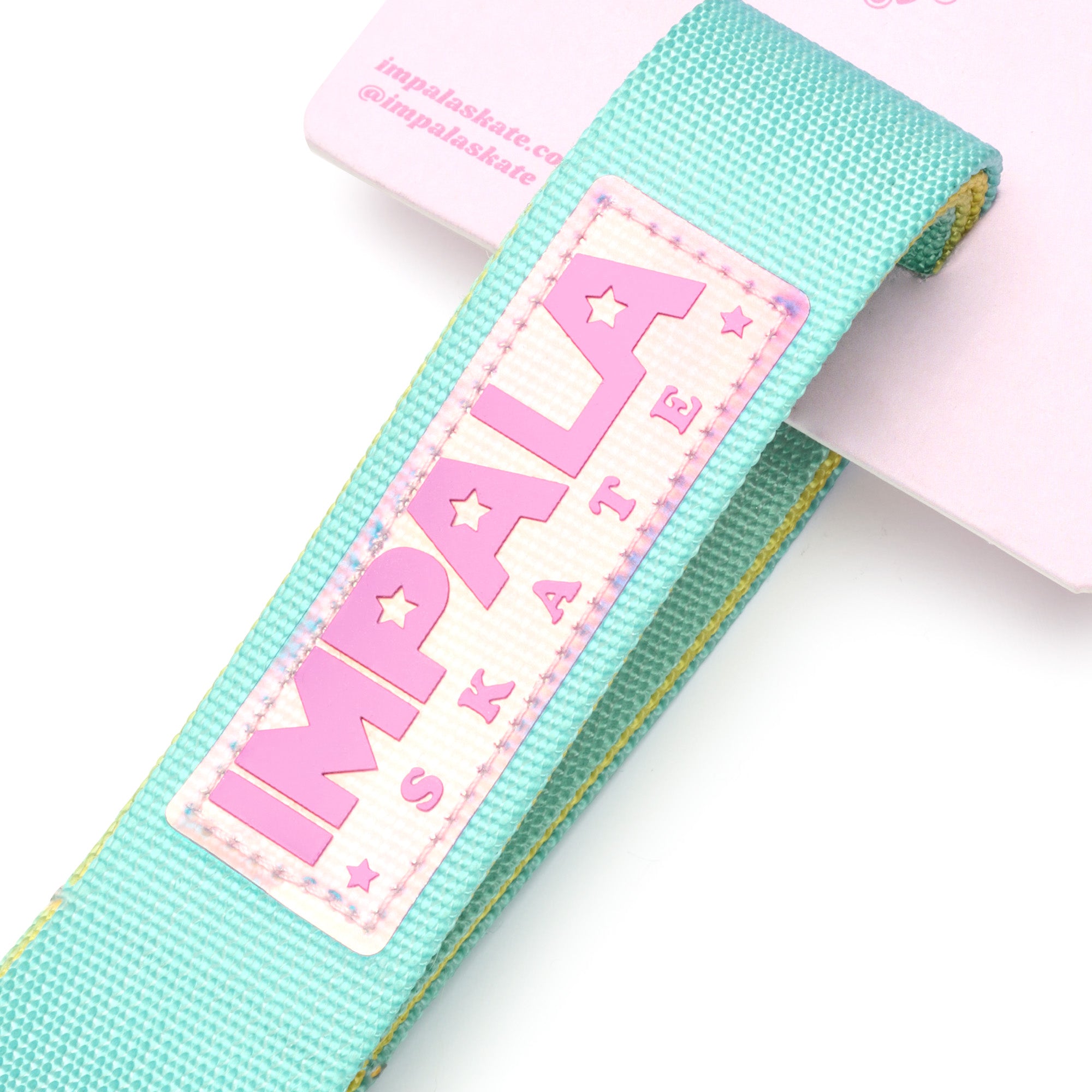 Turquoise skate strap detail with pink IMPALA lettering on woven webbing