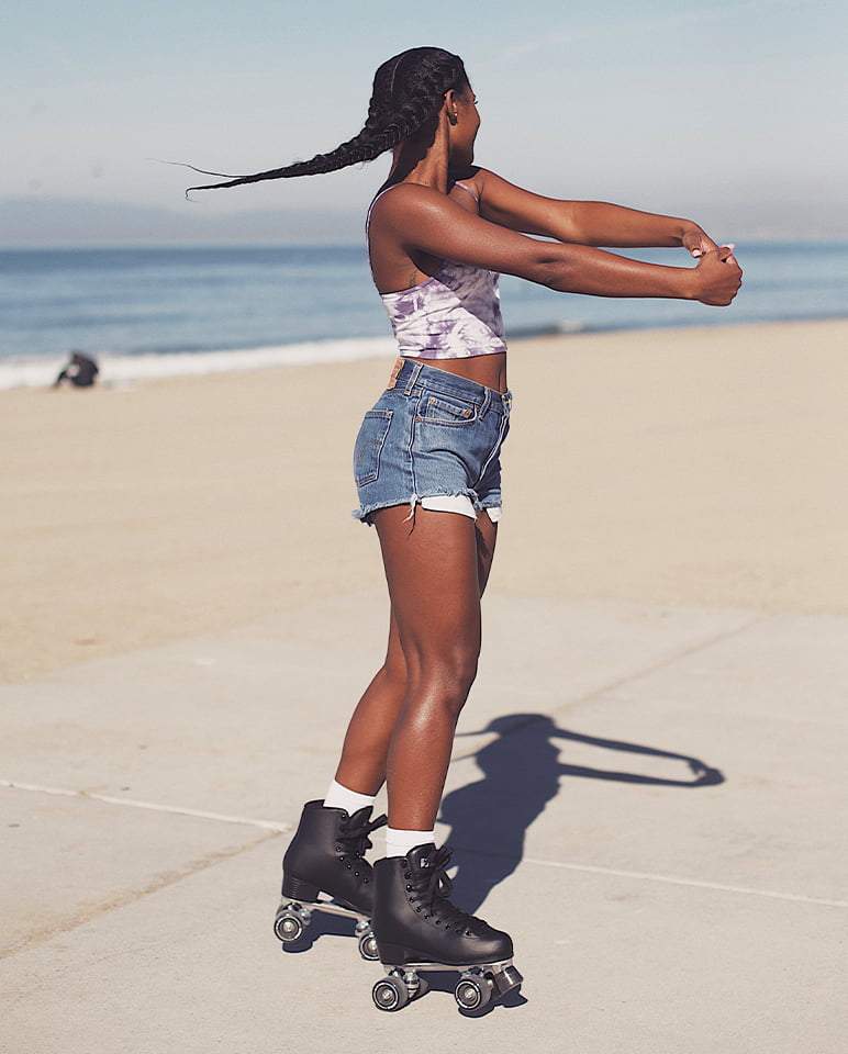 Black quad skates worn on a runner’s feet, four wheels visible