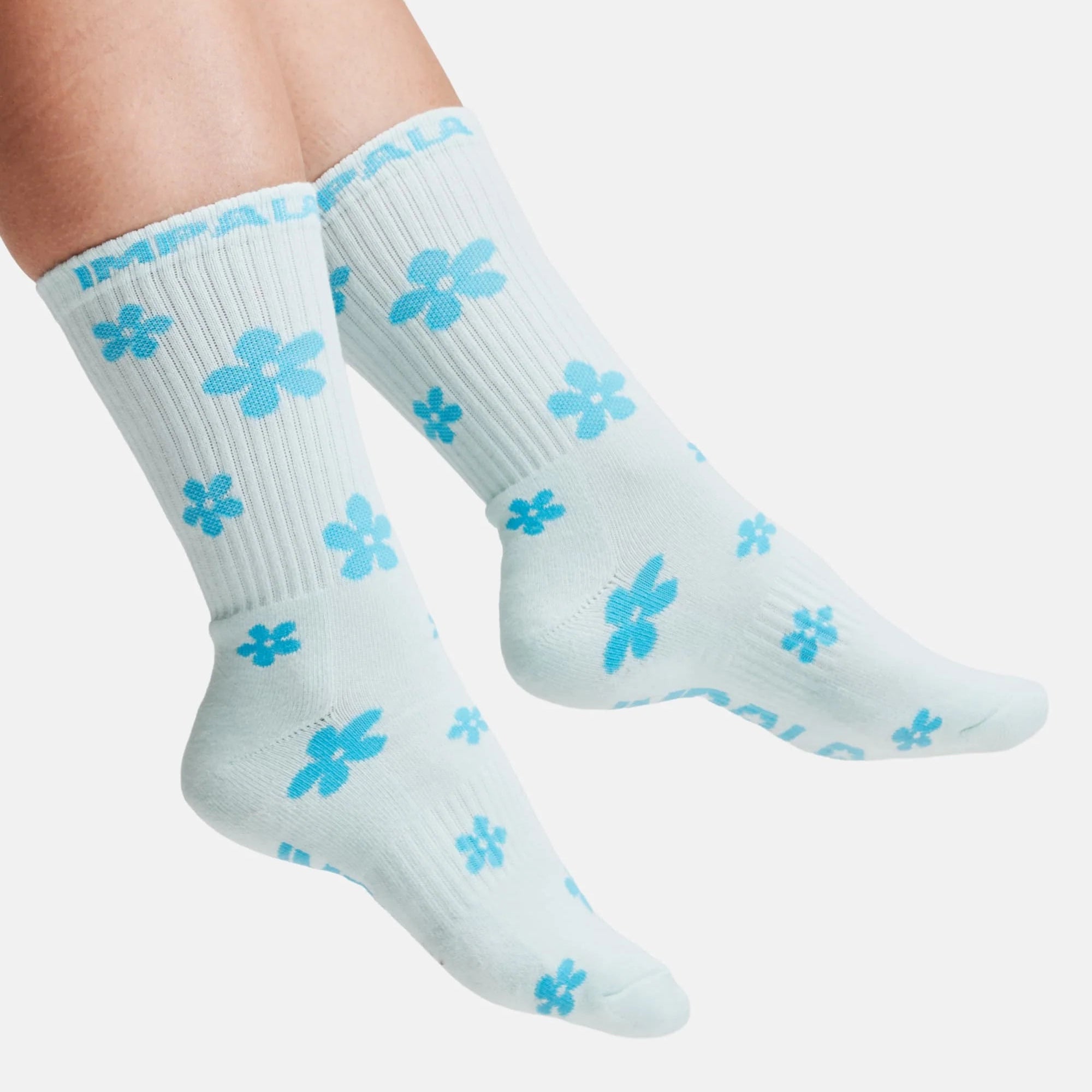 Crew socks on feet, light blue with clover pattern, ribbed knit