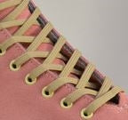 Light tan shoelaces laced through eyelets on a skate shoe