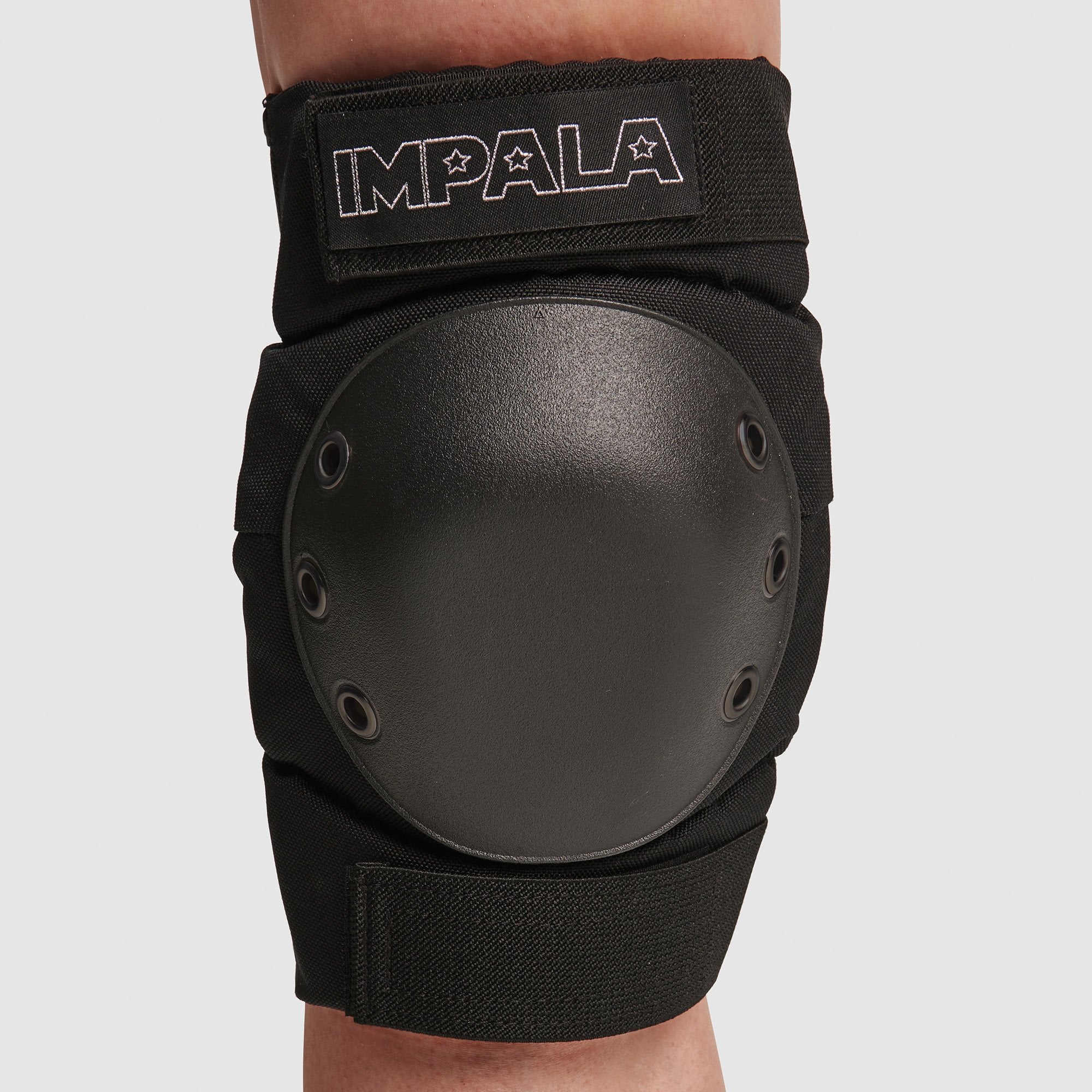 Close-up of black knee pad with round hard shell and IMPALA label