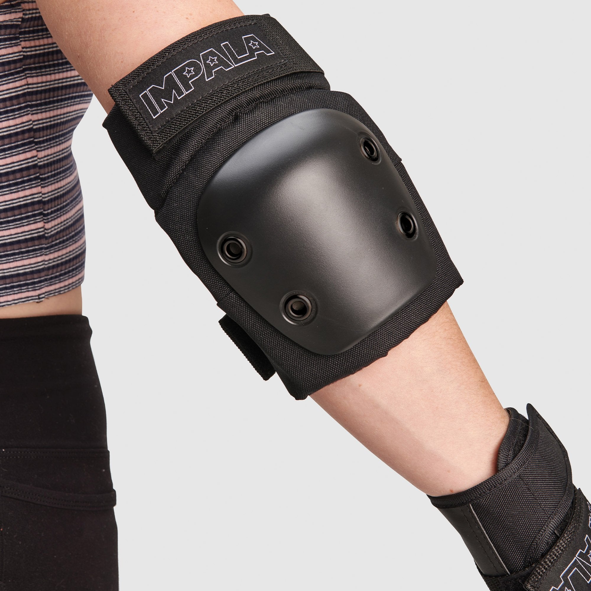 Close-up of black forearm guard with round hard shell and strap