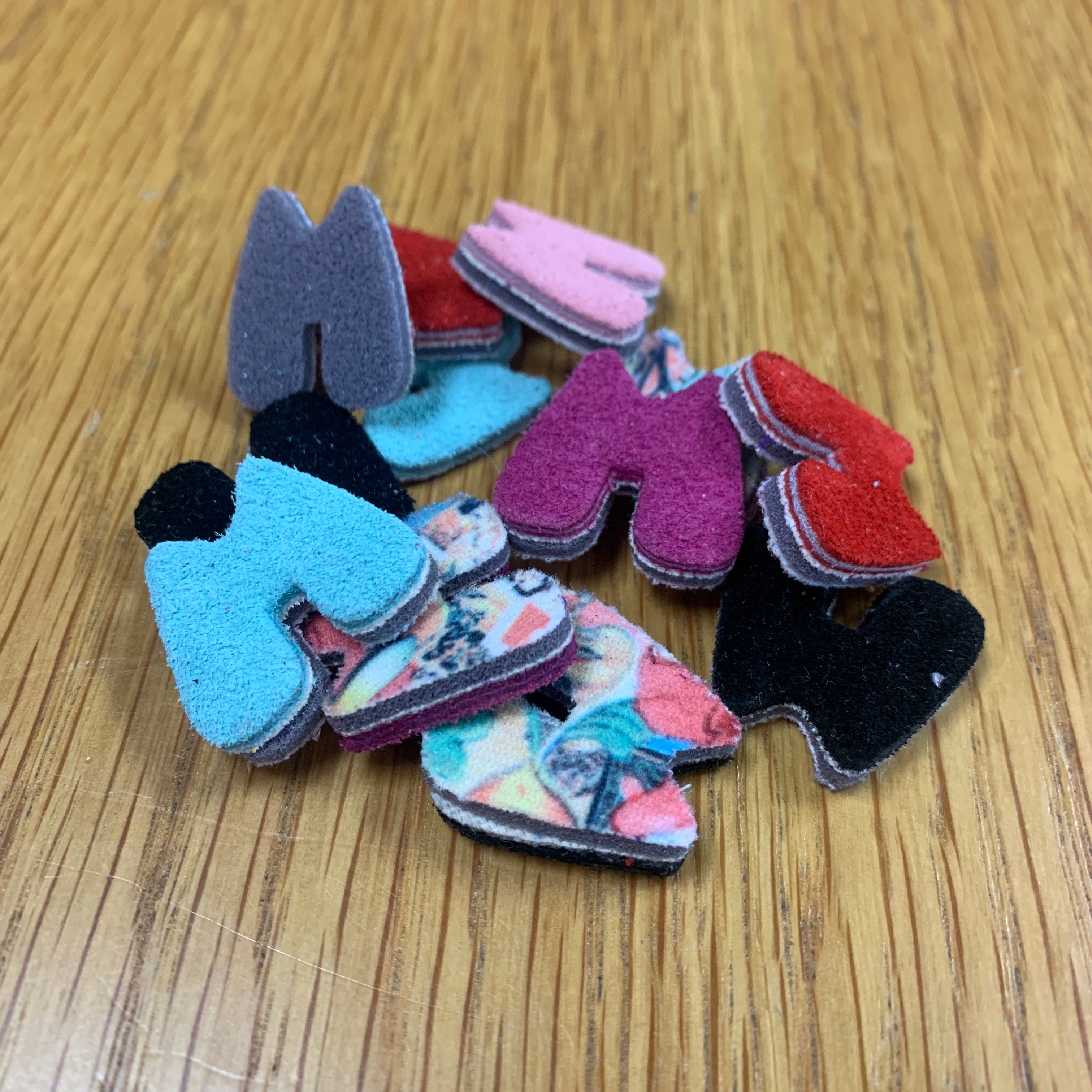 Assorted felt 'M' letter cutouts in blue, red, pink, and black