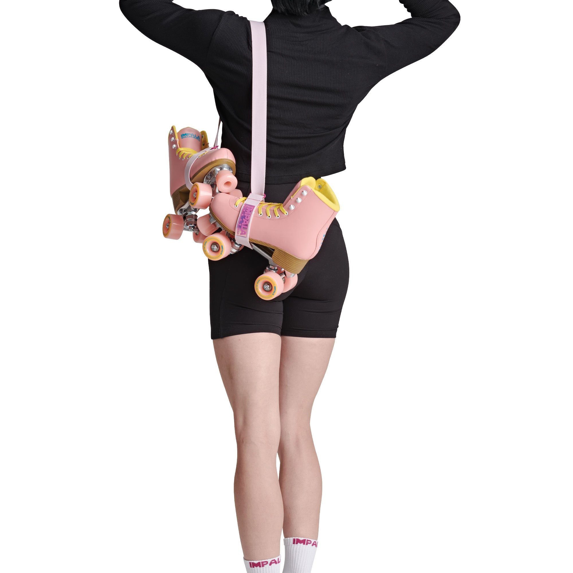 Pink skate strap securing roller skates on a standing person, loop end visible