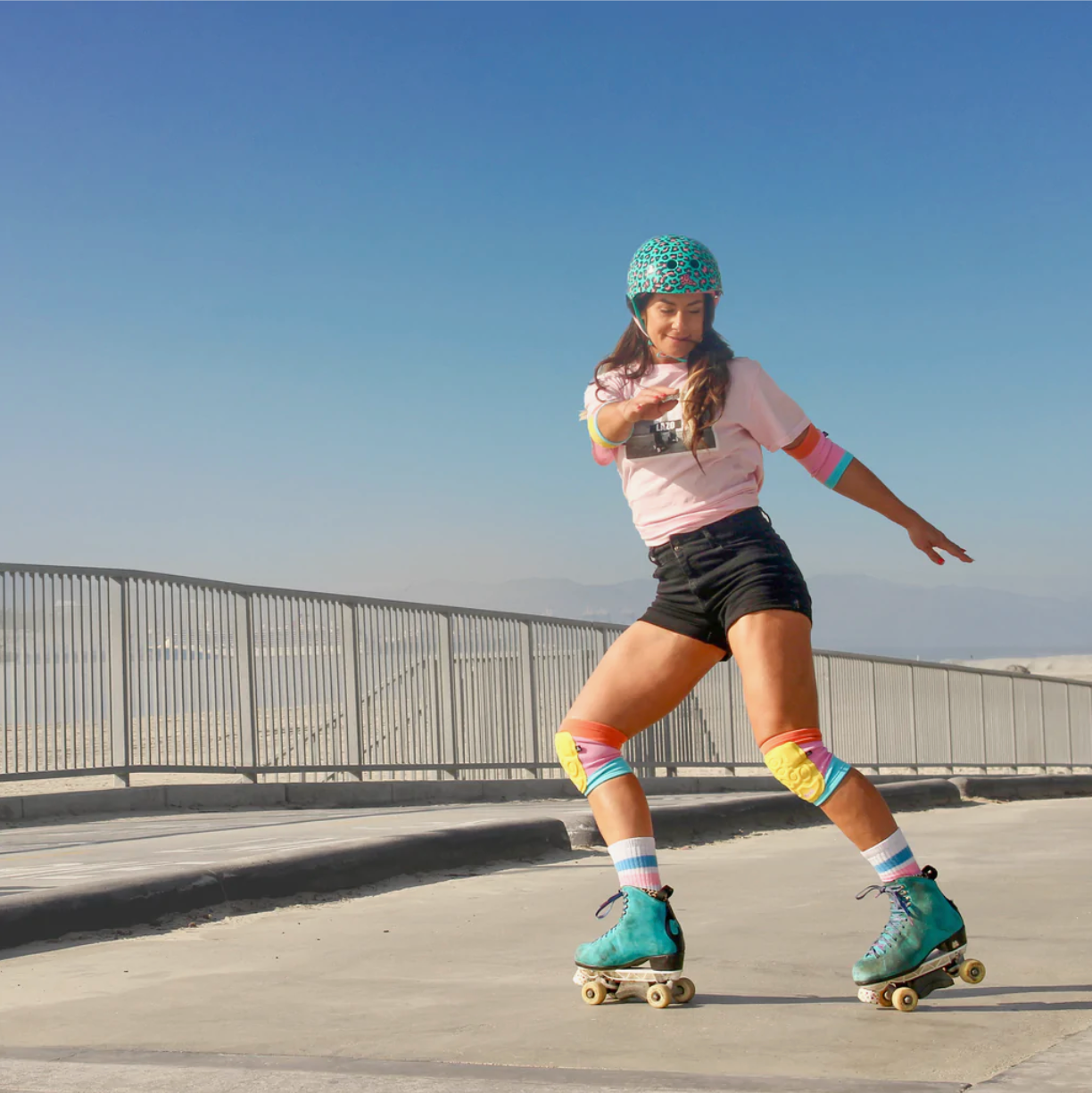 Colorful protective pads with yellow inserts on a skater wearing roller gear