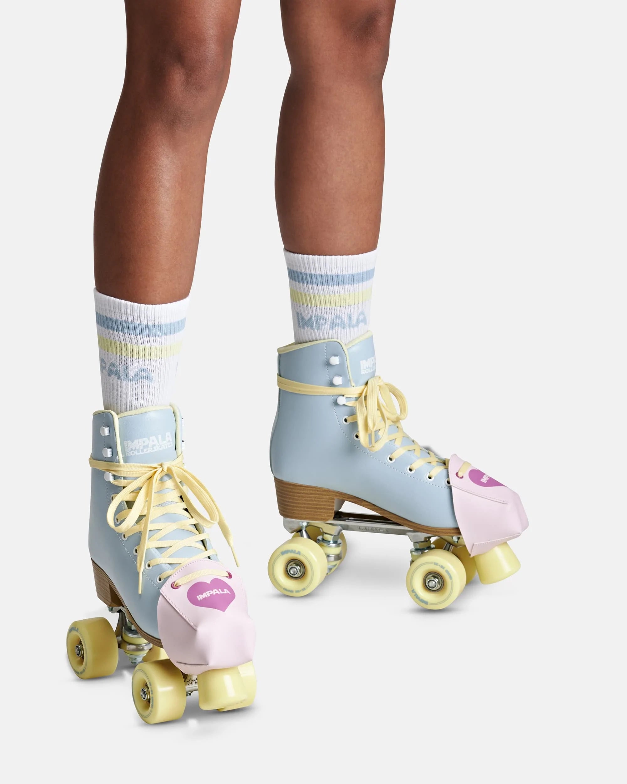 Pink toe guards on roller skates with yellow laces and light-blue boot