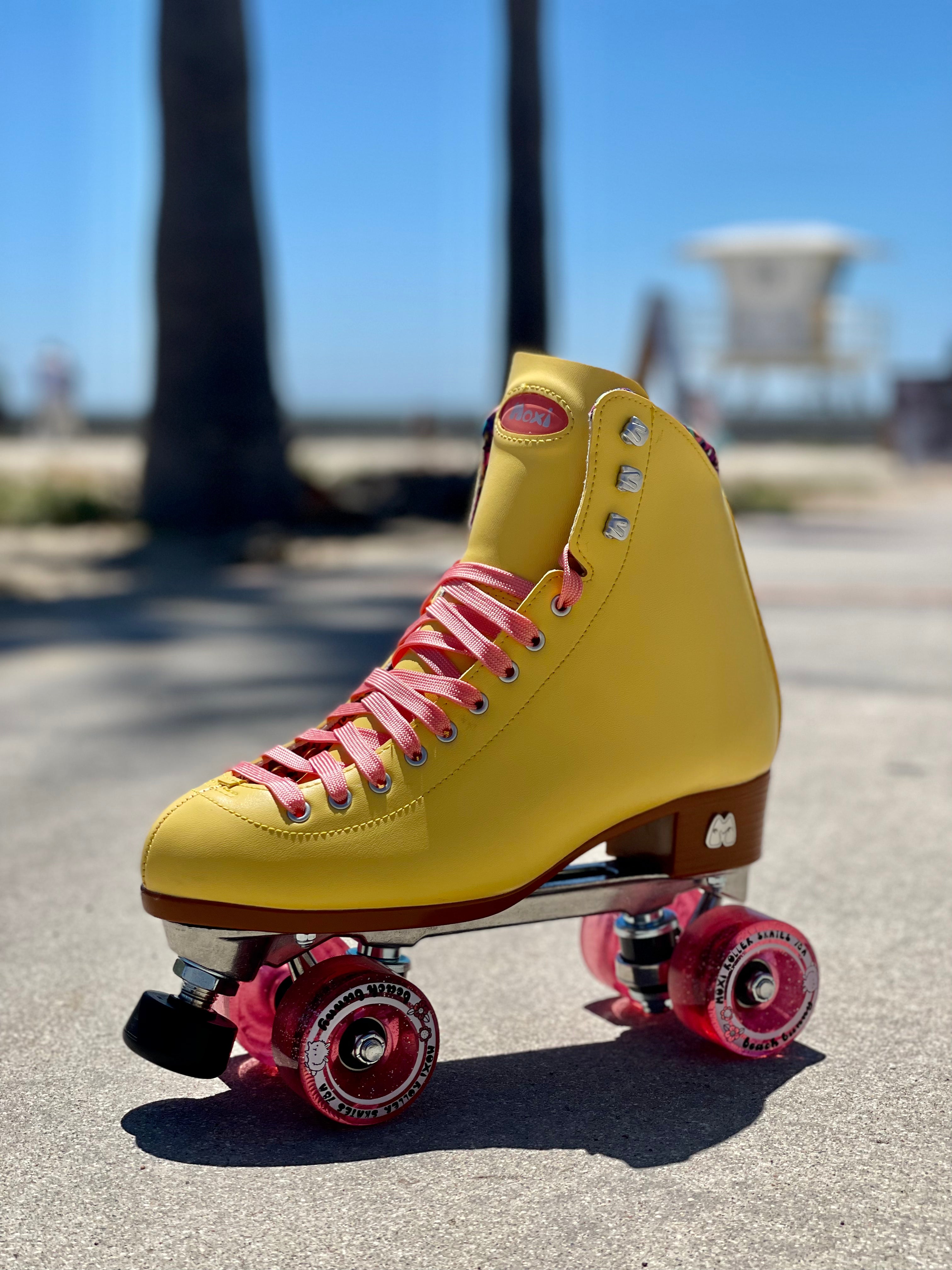 Yellow high-top roller skate with pink laces and red wheels