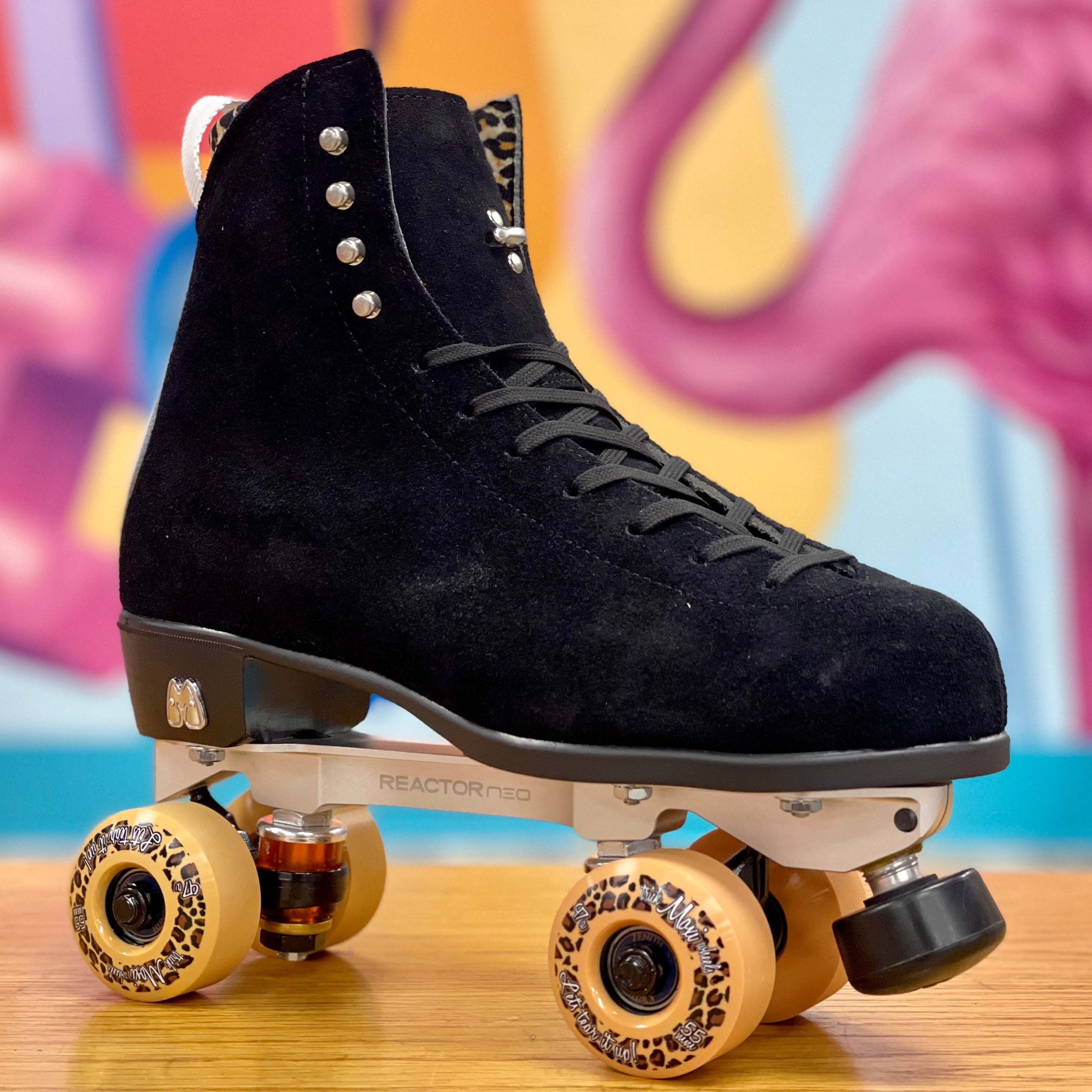 Black high-top suede skate boot on roller skates with yellow wheels
