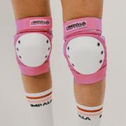 Impala pink padded knee braces worn on legs with white round circular shield